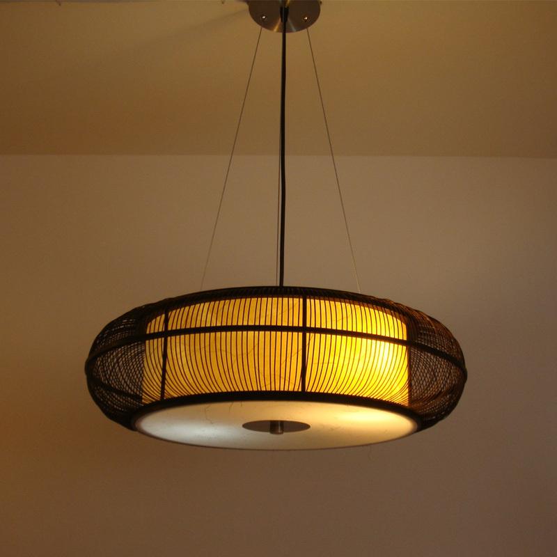 Caged circular pendant light in black or beige